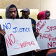 Protesters stand outside the Barneys New York flagship store in New York City.
Andrew Burton/Getty Images